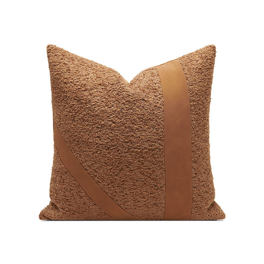 A rust brown pillow with a leather strip