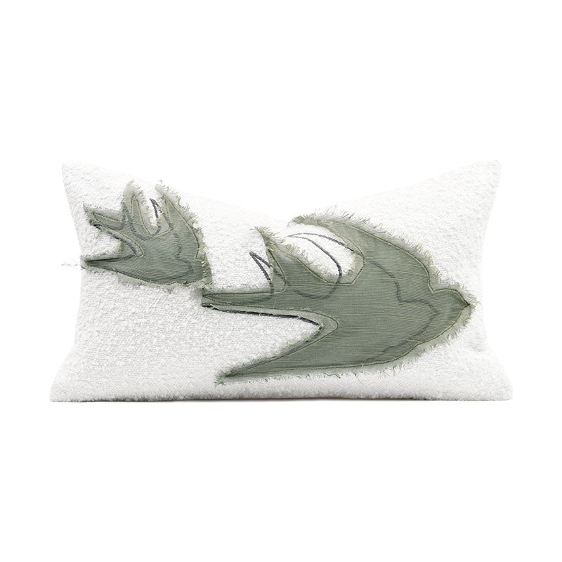 A white decorative pillow with a design on it simulating an abstract bird 