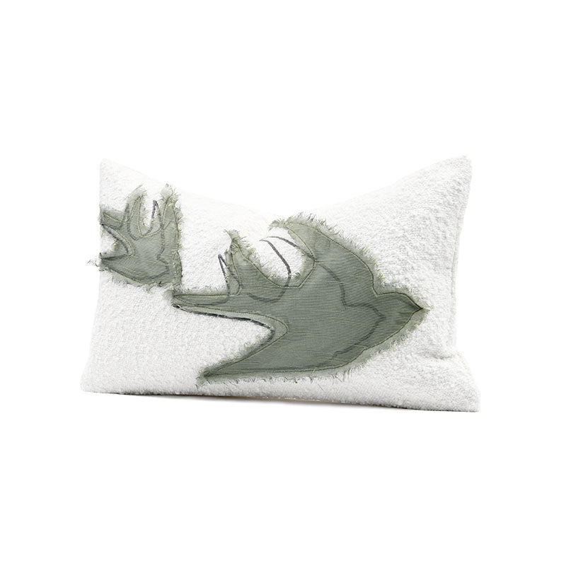 A white decorative pillow with a design on it simulating an abstract bird 