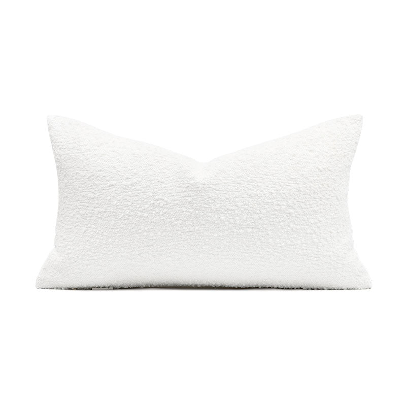 A white decorative pillow with a design on it simulating an abstract bird 