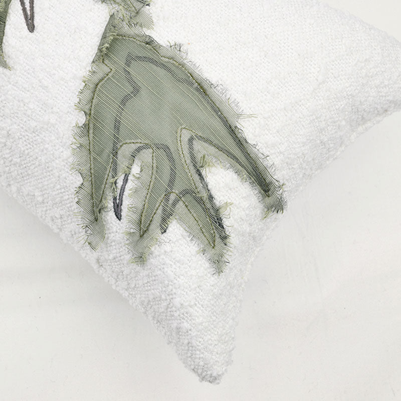 A white decorative pillow with a design on it simulating an abstract bird 